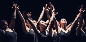 RIC Dance Company members with upstretched arms